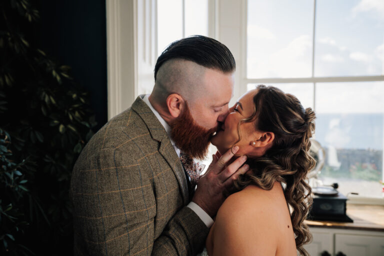 Newly wed couple share their first kiss after their Micro-wedding at Beacon Crag near Porthleven, captured by Cornwall Wedding Photographer Chris Armstrong Photography